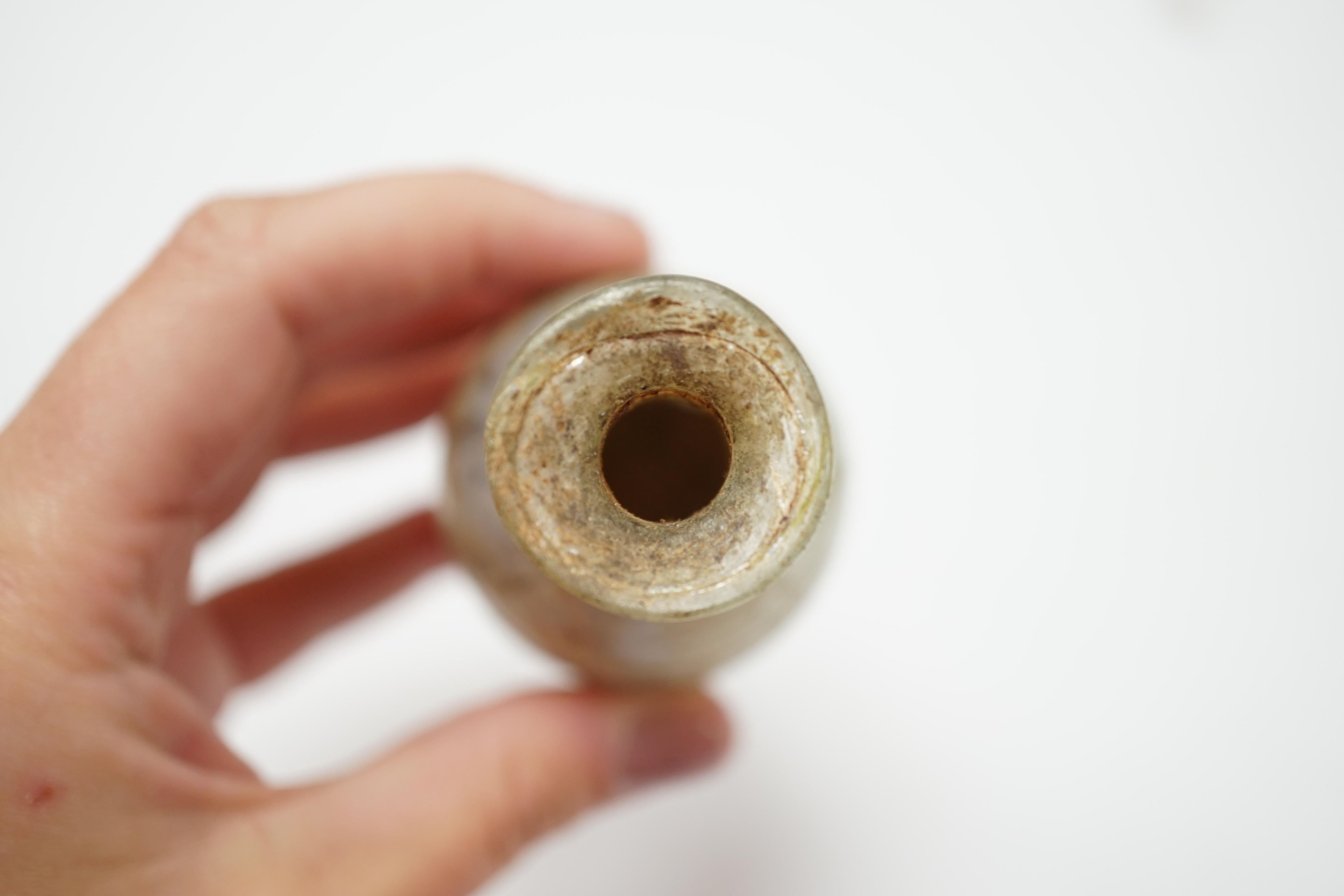 A Roman glass unguentarium, with trailed decoration, 14cm. Condition - poor, has a vertical crack from top to bottom